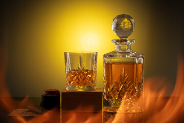 glass of cognac on the yellow dark background with fire