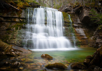 Fototapeta na wymiar Silky waterfall in the mystical green forest