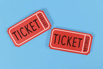 Two old fashioned red tickets on blue background