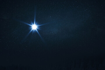 The star shines over the manger of Christmas of Jesus Christ. Bethlehem illuminated by Christ's...