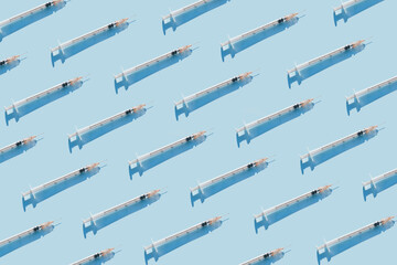 Creative medicinal pattern from syringes of blue background. Colorful concept of Corona virus...