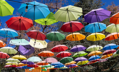 Colorful umbrellas hanging along clothes lines