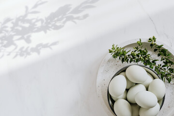 Easter flat lay with green eggs on a white marble