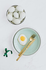 Easter flat lay with green eggs on a white marble