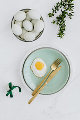 Easter flat lay with green eggs on a white marble