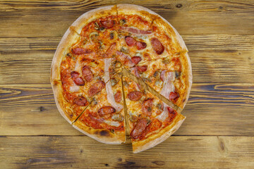 Delicious fresh pizza with sausage, mushrooms and cheese on a wooden table. Top view
