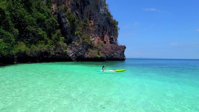 Cute Asian Girl on a Kayak at Monkey Beach, Phi Phi Island, Thailand. Drone.