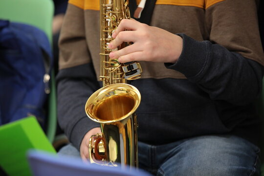 Person in jeans playing saxophone background image jazz concept