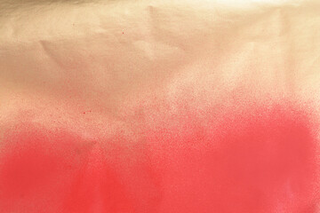 Fototapeta premium red spray paint on gold colored paper