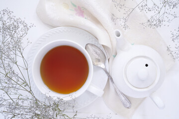Top down view of a cup of tea and a teapot.