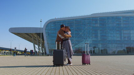 Elderly old grandmother grandfather retirees tourists reunion in airport terminal after long separation traveling. Lovely senior couple husband and wife happily hugging meeting after business trip