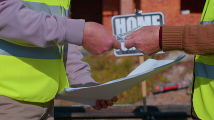 Close-up hands of real-estate agent selling new house to grandfather. Male realtor receive money dollar cash from man. Aged retired grandparent buying new home. Successful agreement contract reached