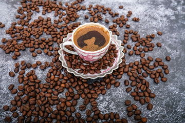 Roasted brown coffee beans and Turkish coffee on the rustic table.