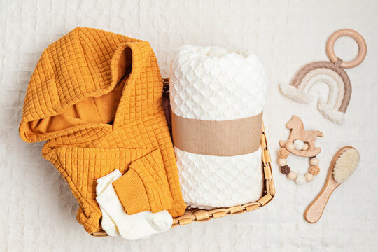 Collection of cute organic  baby clothes, toys and blanket. Heartwarming present for cold weather of fall and winter season. Newborn gifts for Christmas and baby shower, donation idea. 