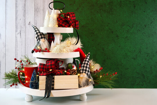 Christmas holiday on-trend Farmhouse aesthetic three tiered tray decor filled with festive decorations, farmhouse style stack of books and gnomes. Negative copy space.