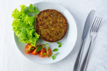 carne de proteína vegetal acompañado de tomate y lechuga en un plato