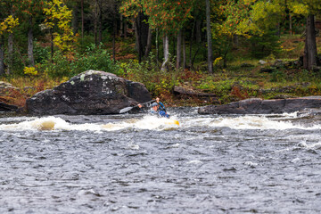 A solo canoeist practices strokes on a rainy fall day during  a “moving water” paddling course....