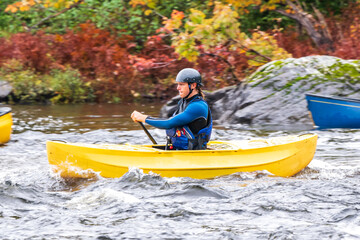 A solo canoeist practices strokes on a rainy fall day during  a “moving water” paddling course. Shot at Palmer Rapids on the Madawaska River an iconic paddling destination in Eastern Ontario, Canada