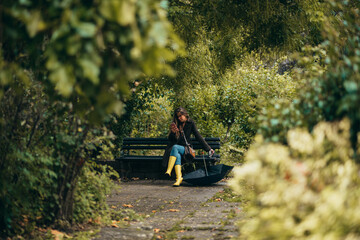 Woman using smartphone while sitting on a bench in the park