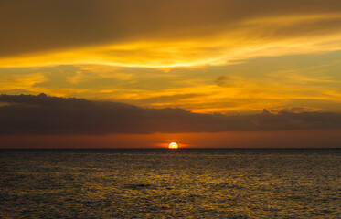 Beautiful sunset in red and orange tones on the shore of the beautiful and quiet Holbox beach in Quintana Roo, Mexico.