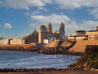 View of the famous cathedral of Cadiz at sunset from the beach. Tourism concept