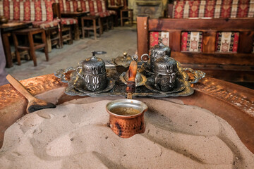 Turkish coffee brewing process in the sand and elderflower syrup, Sirince, İzmir, Turkey.
