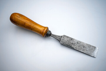 Vintage wooden chisel with wooden handle on white isolate. A hand tool for working with wood. A red - hot blade .