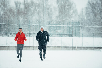 Young couple going for a run together during a snow