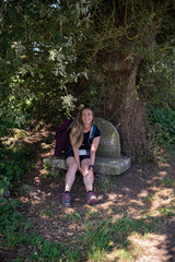 Mujer joven y cansado haciendo el camino de peregrinación hacia Santiago un día caluroso de verano