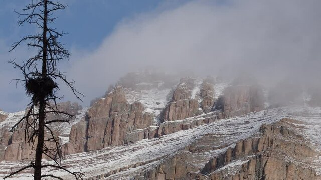 Clouds moving over the snowy cliff face of Hayden Peak in the Uinta Mountains after snow storm.