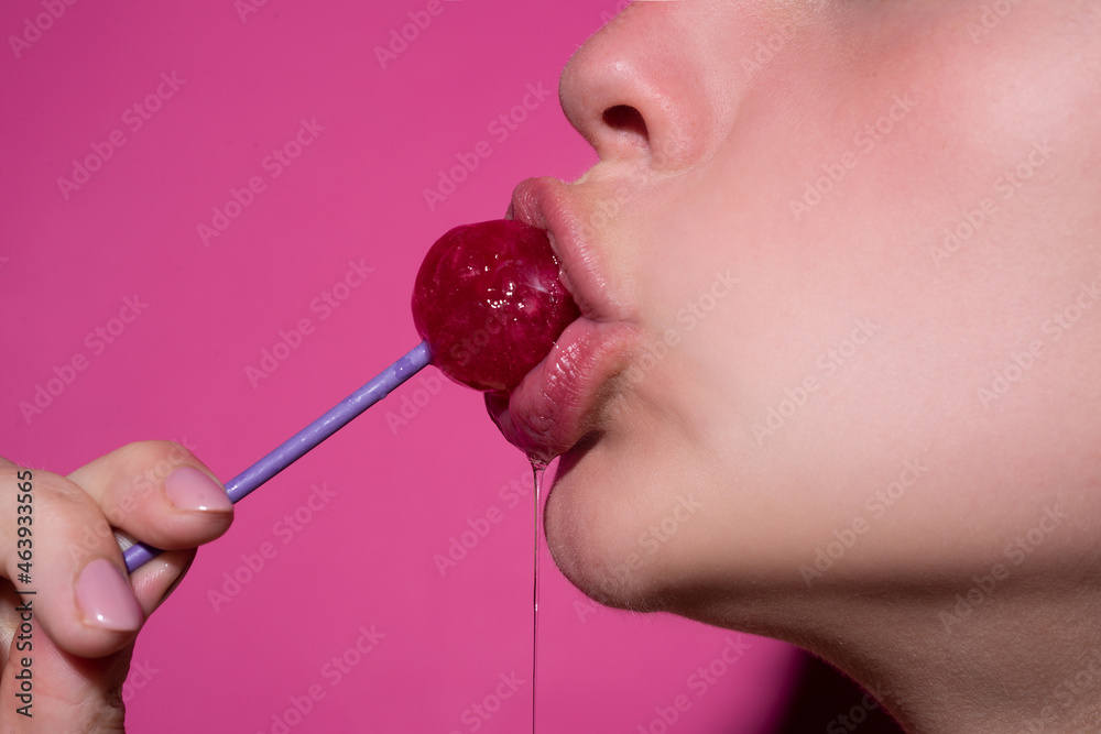 Wall mural close up, model sucking a red lollipop