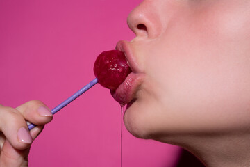 Close up, model sucking a red lollipop