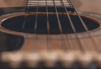Obraz premium closeup of guitar sound hole looking down the strings of wood acoustic guitar of musician