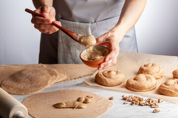 closeup isolated image of a caucasian woman preparing sweet Turkish pastry rolls with tahini and...