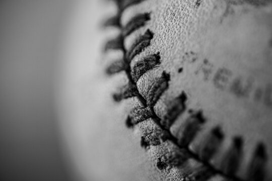 artistic close-up of professional game baseball and stitching macro black and white or monochrome filling frame with heavy bokeh