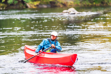 A solo canoeist practices on a rainy fall day during a &ldquo;moving water&rdquo; paddling course. Shot at Palmer Rapids on the Madawaska River an iconic paddling destination in Eastern Ontario, Canada