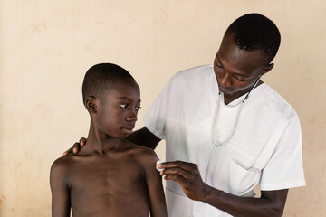 Doctor disinfecting the injection site on a black boy's arm after malaria vaccination in West Africa