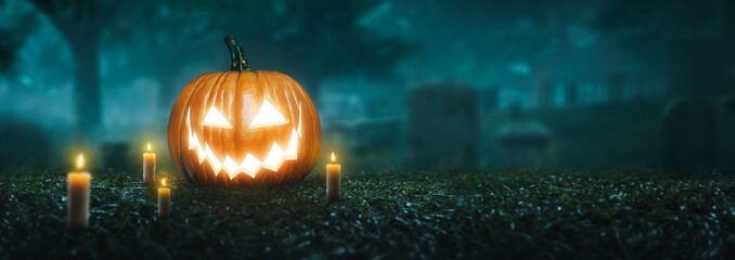 Pumpkin Jack O 'Lantern with creepy glowing eyes on Halloween night in the graveyard