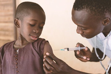 Black toddler at his first antimalarial vaccination in a small rural African dispensary - obrazy, fototapety, plakaty