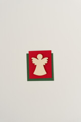 isolated wooden christmas angel shape or silhouette cut out arranged on paper squares