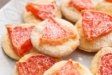 Plate with tasty grapefruit cookies, closeup