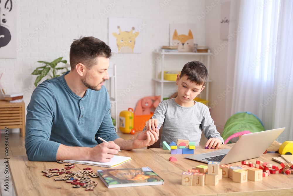 Poster male psychologist working with little boy in office. autism concept