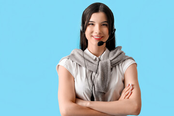 Beautiful consultant of call center in headset on blue background