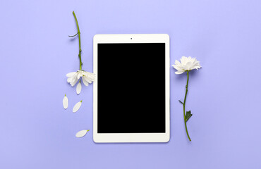 White tablet computer with flowers on color background