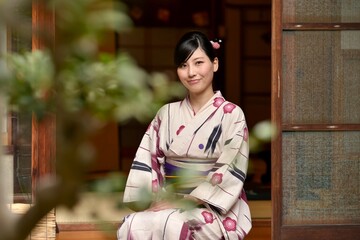 京都町屋にて縁側でくつろぐ浴衣姿の若い女性