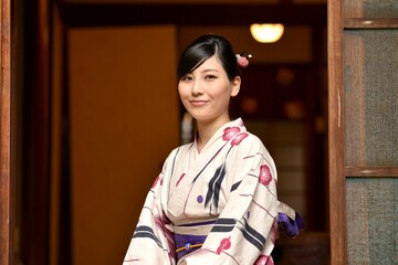 京都町屋の縁側で微笑む浴衣姿の微笑む若い女性	