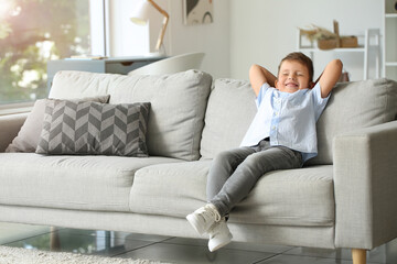 Fototapeta premium Cute little boy relaxing on sofa at home