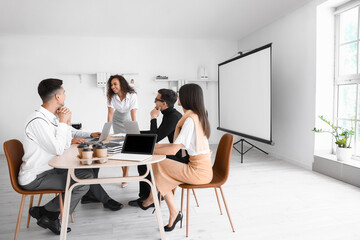 Young business colleagues working at table in office