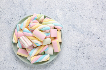 Plate with sweet colorful marshmallows on light background