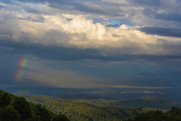 Obraz premium Bright rainbow column over the mountains and forest. Panoramic view from Mon Jam Hill ,Chiang Mai in Thailand